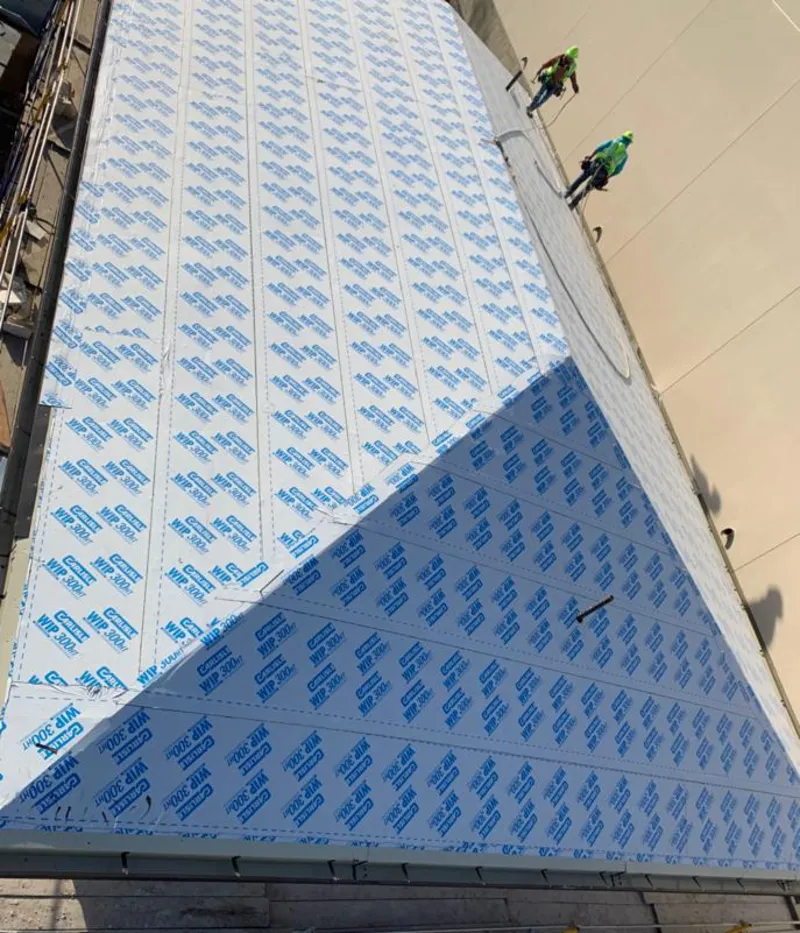 Professional roofers installing underlayment on a metal roof in Aliso Viejo